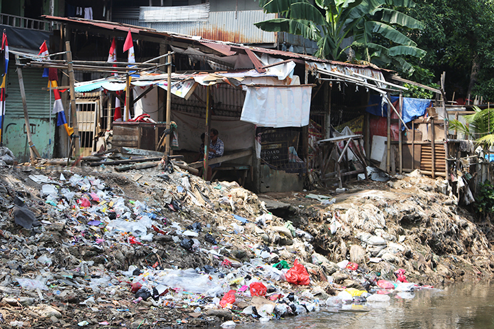 Seorang warga sedang duduk di pinggir kali Ciliwung kawasan Manggarai, Jakata Senin (12/8/2024). (Foto: Edwin B/ Muslim Obsession)