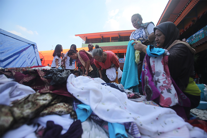 Warga terdampak kebakaran Manggarai memilah sumbangan baju layak pakai di posko pengungsian SDN 05 Manggarai, Jakarta, Rabu (14/8/2024). (Foto: Edwin B/ Muslim Obsession) 