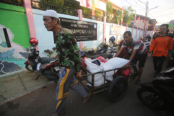 Sejumlah warga membawa pakaian layak pakai untuk korban kebakaran Manggarai di posko pengungsian SDN 05 Manggarai, Jakarta, Rabu (14/8/2024). (Foto: Edwin B/ Muslim Obsession) 