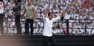 Capres nomor urut 01 Joko Widodo berlari menuju panggung saat menghadiri Konser Putih Bersatu di Stadion Utama Gelora Bung Karno, Senayan, Jakarta