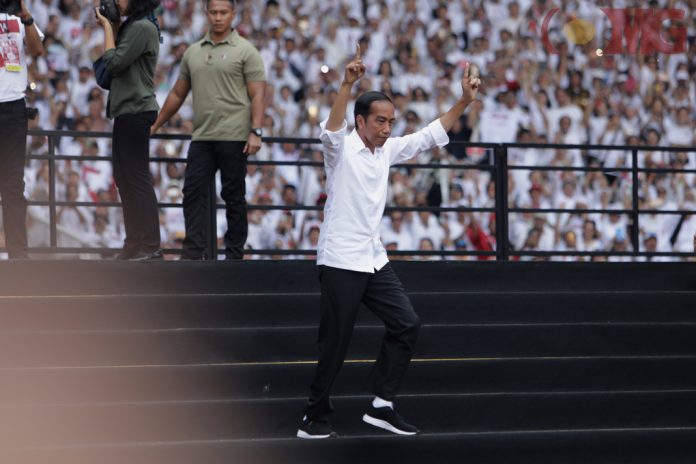 Capres nomor urut 01 Joko Widodo berlari menuju panggung saat menghadiri Konser Putih Bersatu di Stadion Utama Gelora Bung Karno, Senayan, Jakarta