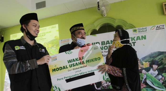 (Ki-Ka) Direktur ACT, Ardiansyah didampingi perwakilan dari Dewan Masjid Indonesia (DMI), Ust. Yusuf Asmawi memberikan wakaf modal usaha mikro secara simbolis kepada salah satu warga di Jakarta, Jumat (4/9/2020).